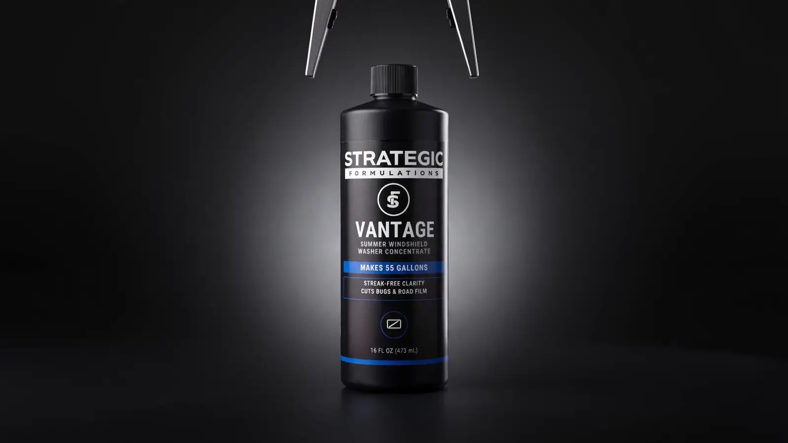 A robotic gripper placing a capped Vantage bottle under a studio light